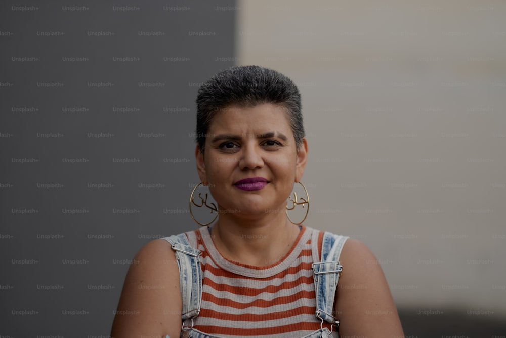 a woman in a striped dress with large hoop earrings