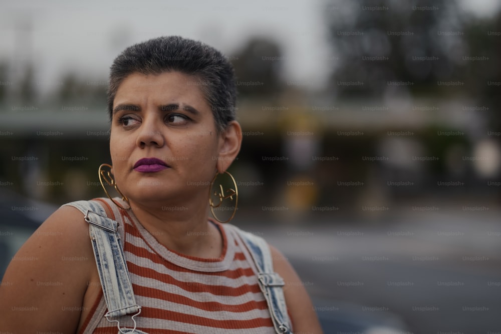 a woman in a striped shirt with large hoop earrings