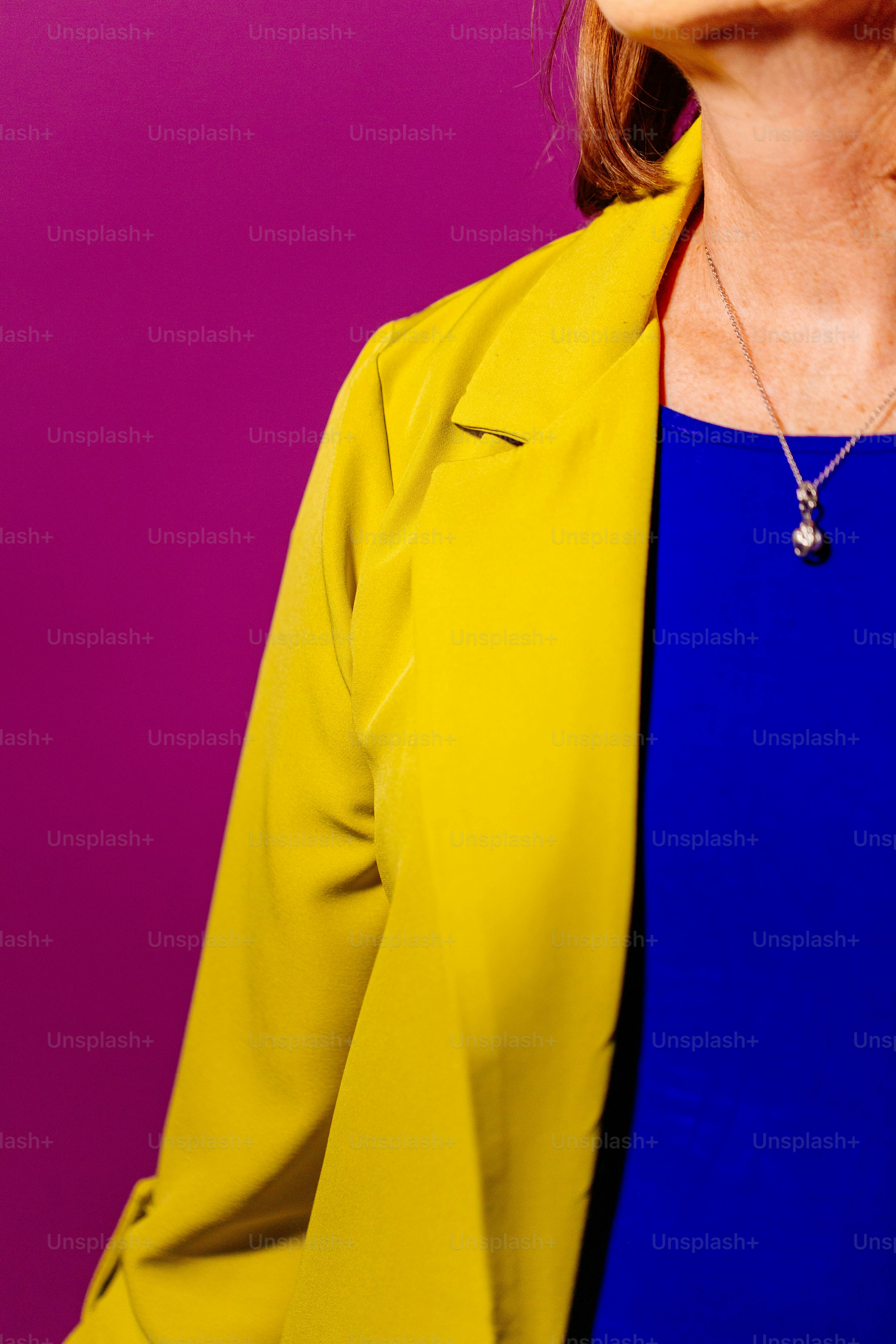 Una donna in un top blu e giacca gialla