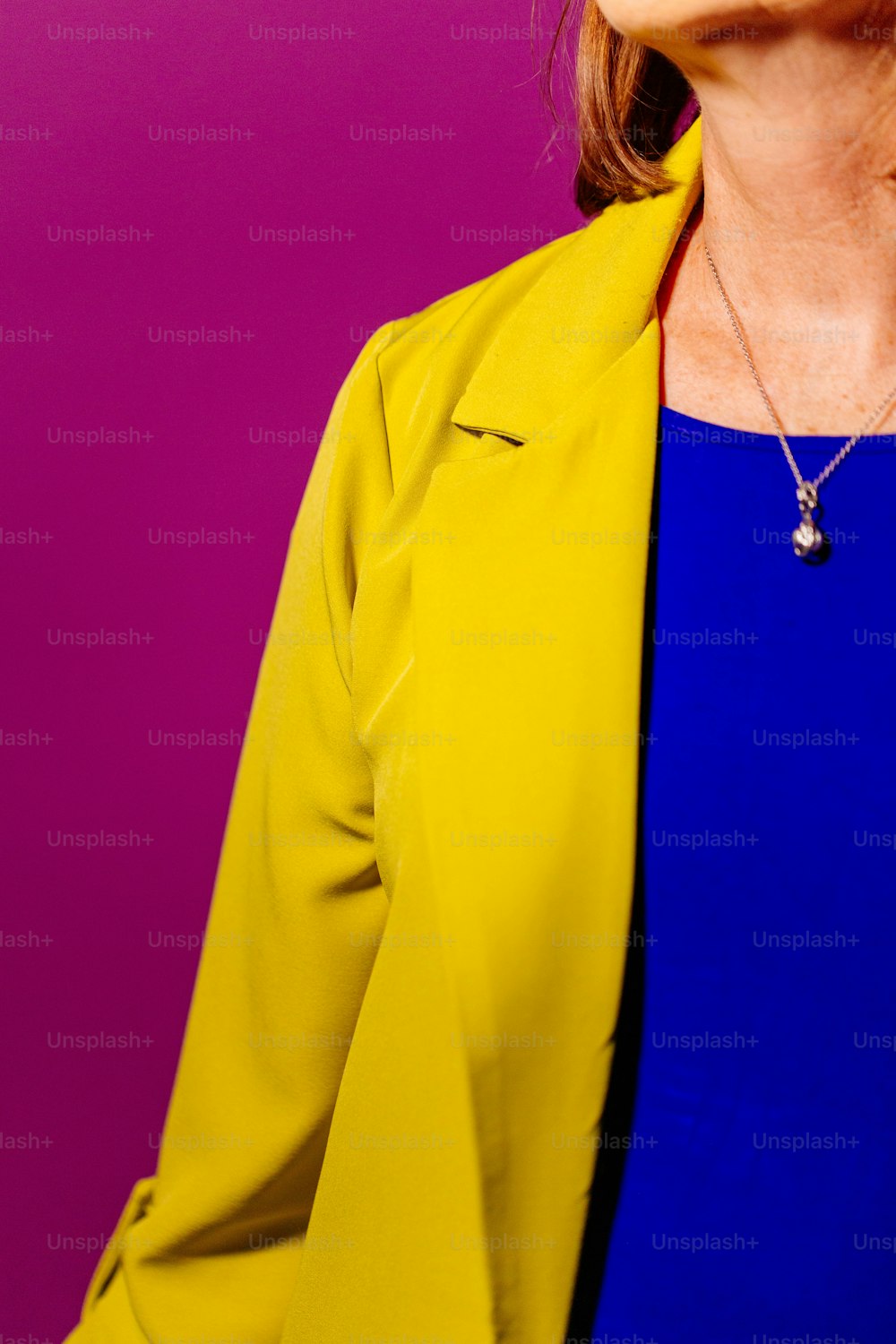 Una donna in un top blu e giacca gialla