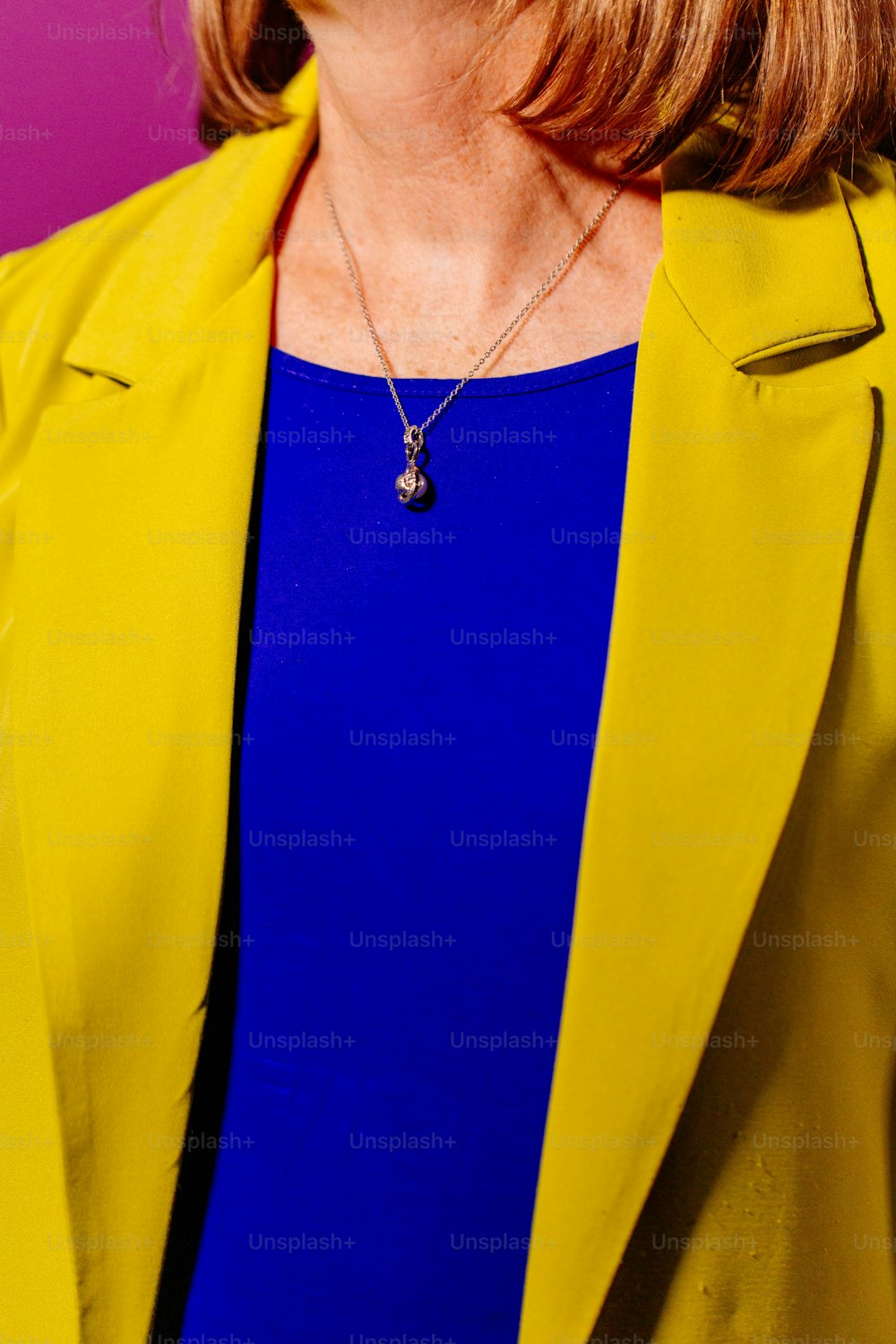 une femme vêtue d’une veste jaune et d’un haut bleu