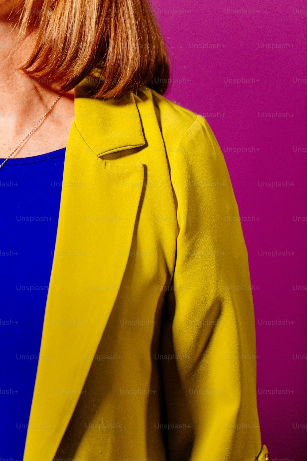 Eine Frau in blauem Kleid und gelber Jacke