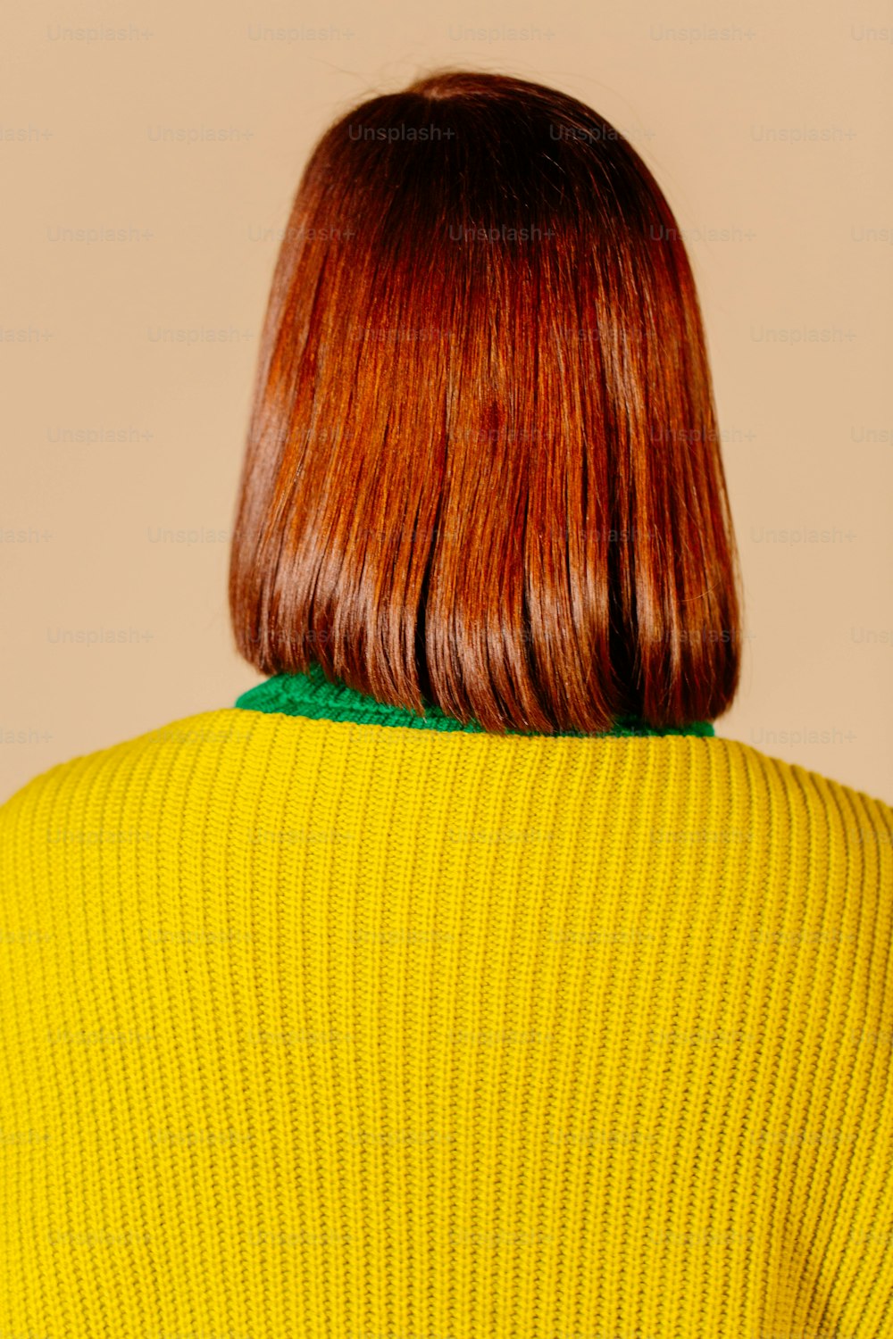 a woman with red hair wearing a yellow sweater