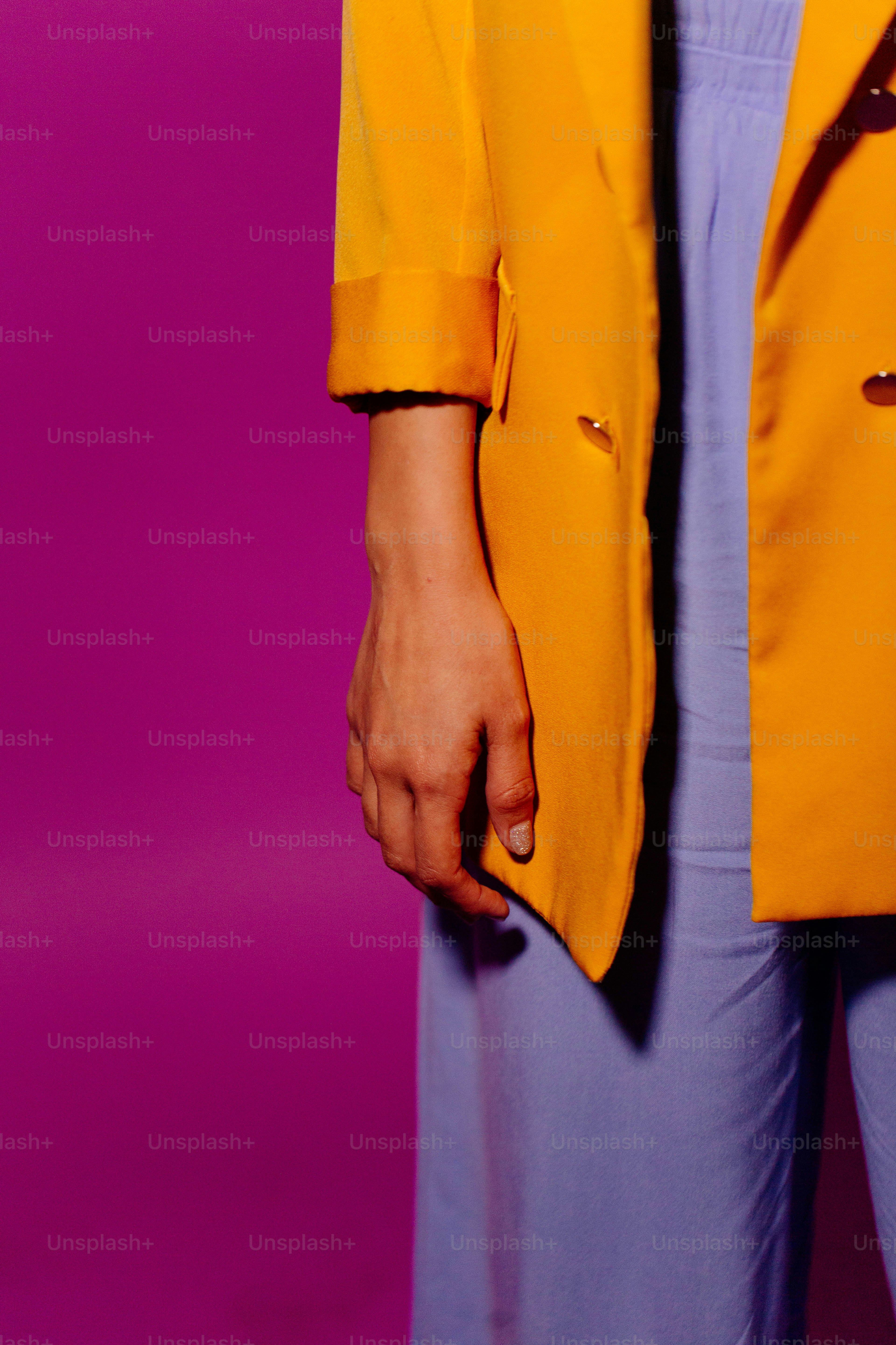 una persona che indossa una giacca gialla e pantaloni blu