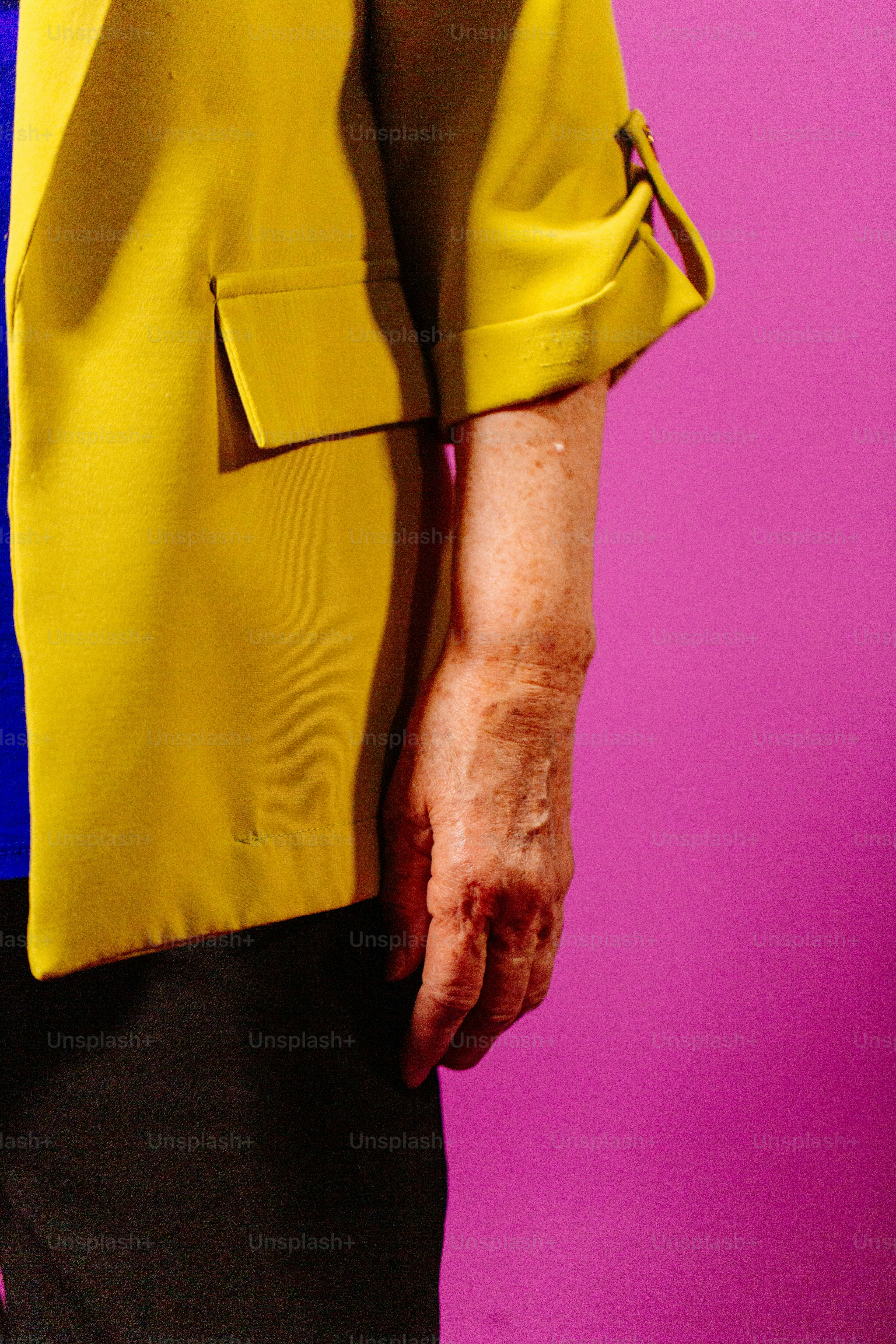 una persona che indossa una giacca gialla e pantaloni neri