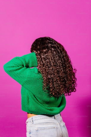 Una mujer con cabello rizado con un suéter verde
