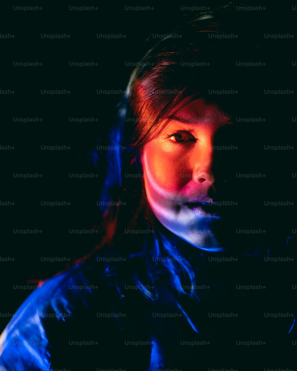 a woman in a dark room with a red light on her face