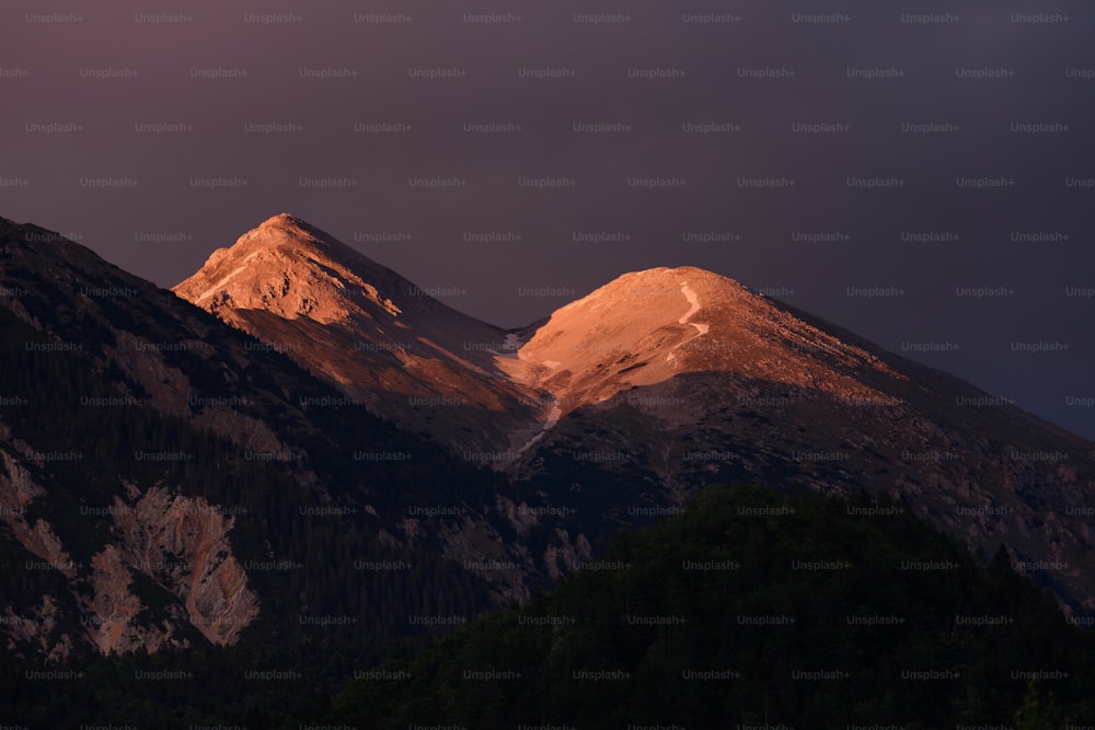 the sun is setting on a mountain range