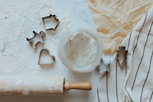 a cookie cutter, cookie cutters, and dough on a table