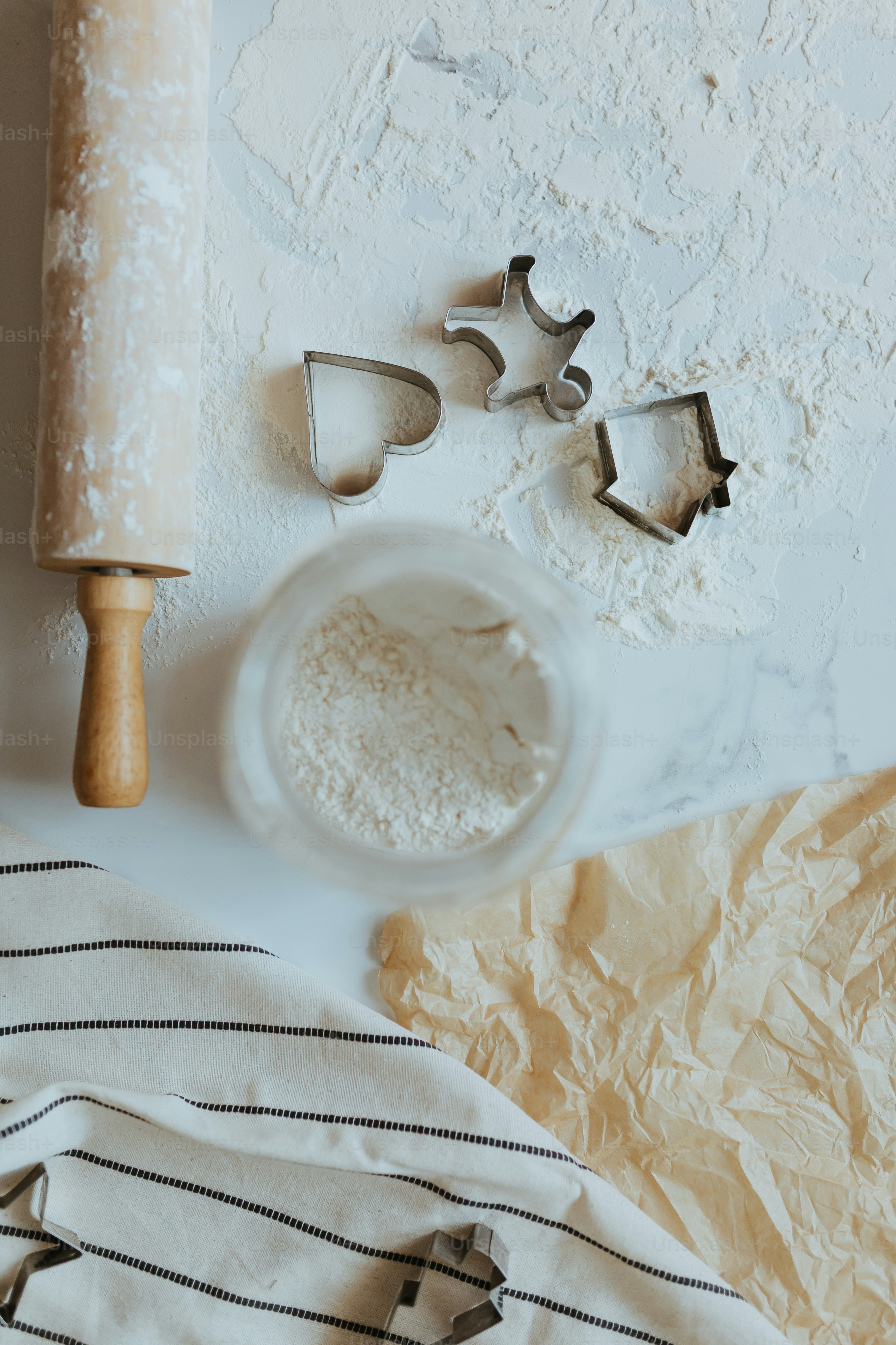 a table topped with a pastry cutter and a bowl of flour