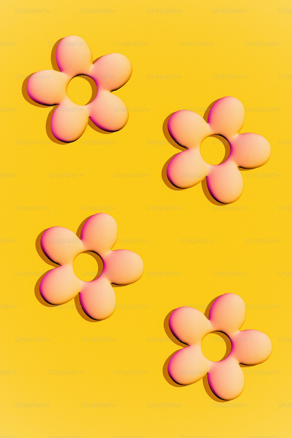 um grupo de flores cor-de-rosa sentadas em cima de uma superfície amarela