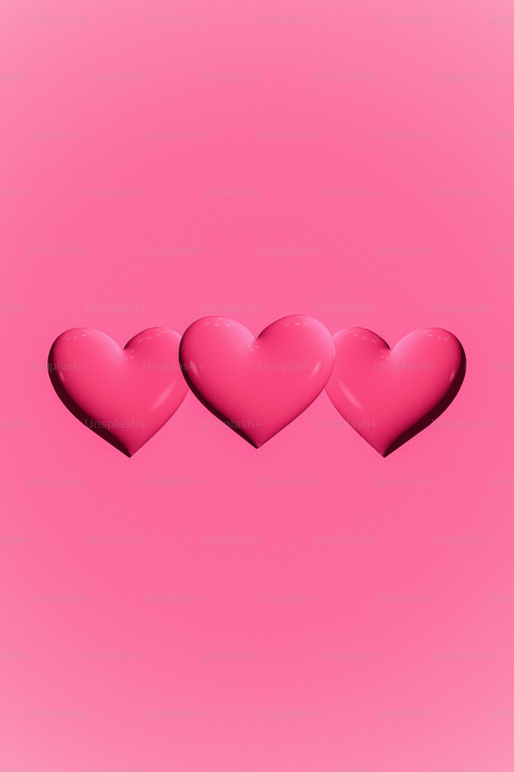 três corações cor-de-rosa em um fundo cor-de-rosa