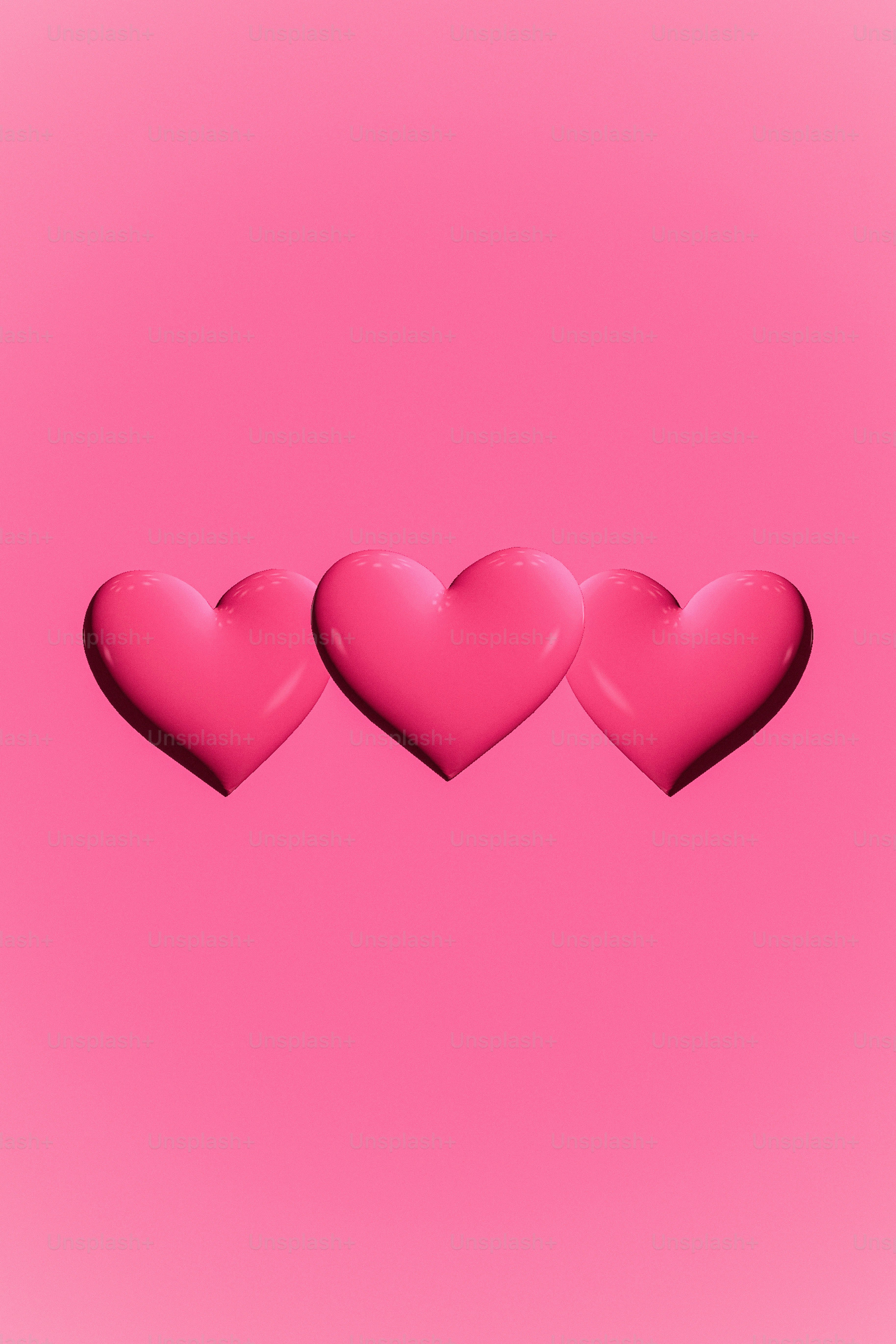 three pink hearts on a pink background