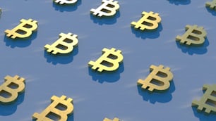Un grupo de bitcoins dorados sentados encima de una superficie azul