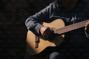 a person sitting down playing a guitar