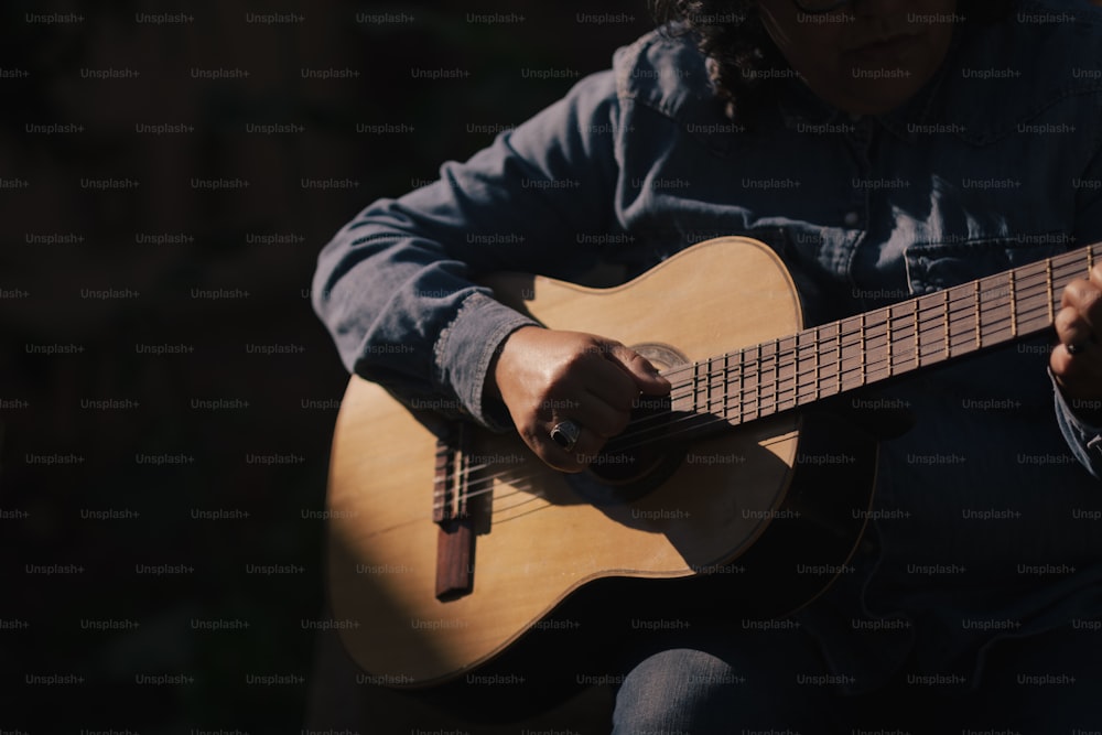 una persona sentada tocando una guitarra