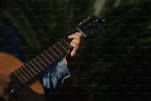 um homem segurando uma guitarra em sua mão direita