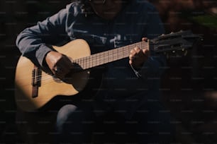 a man is playing a guitar outside