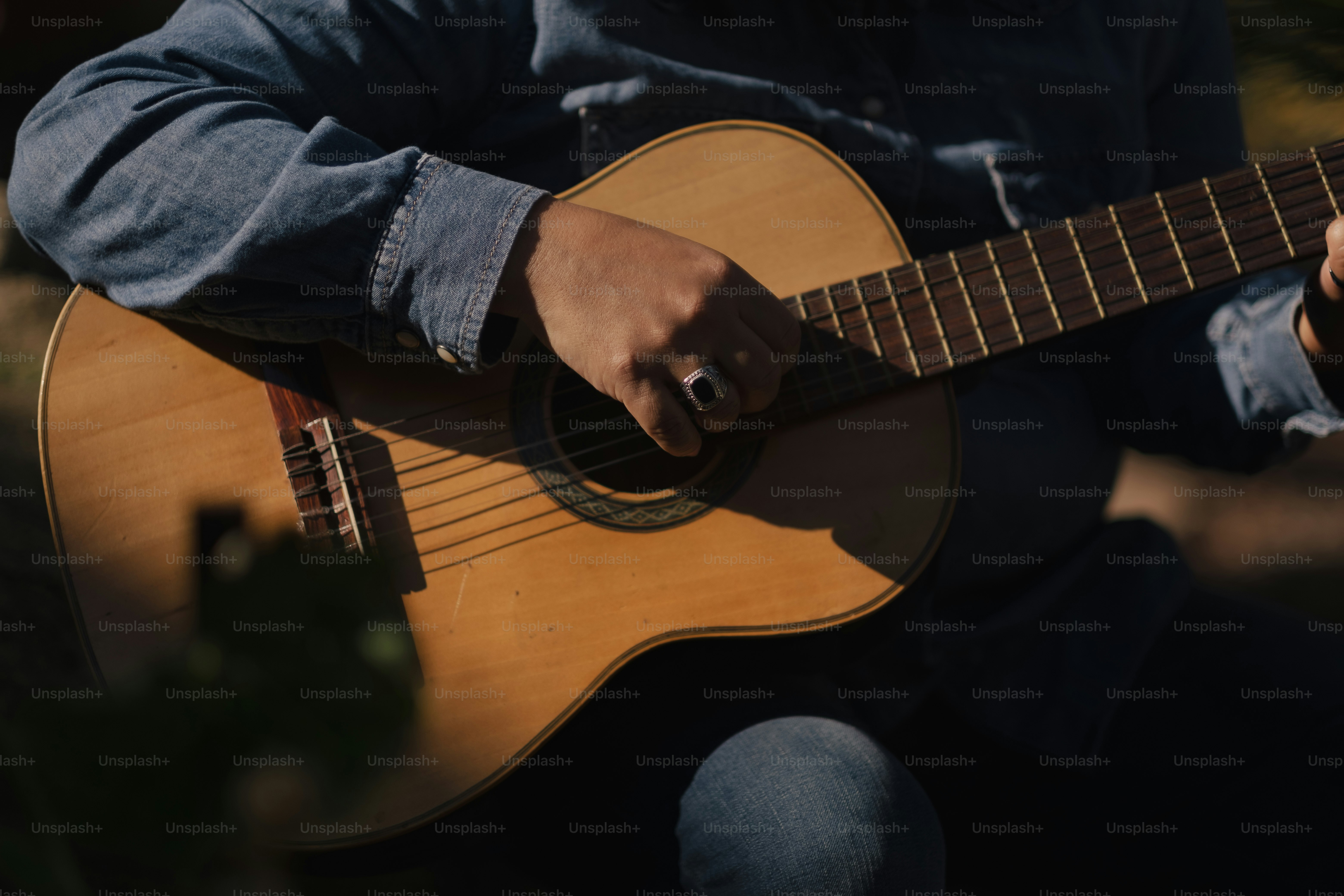 A person sitting down playing a guitar photo – Guitar Image on Unsplash