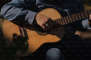 a man is playing an acoustic guitar outside