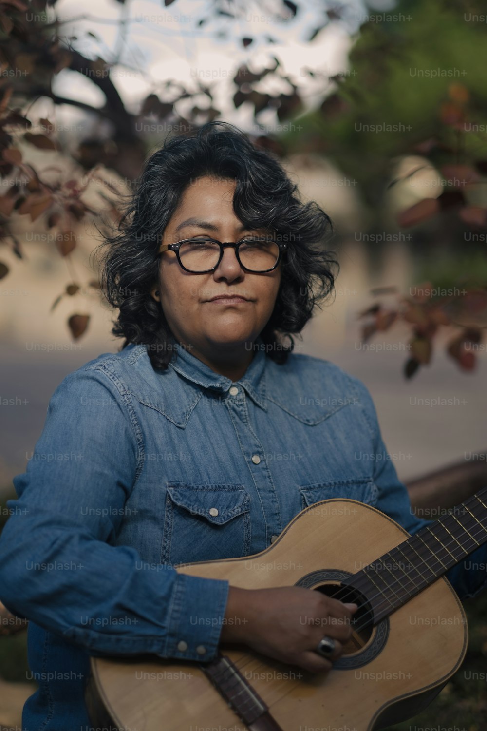 a woman with glasses is holding a guitar