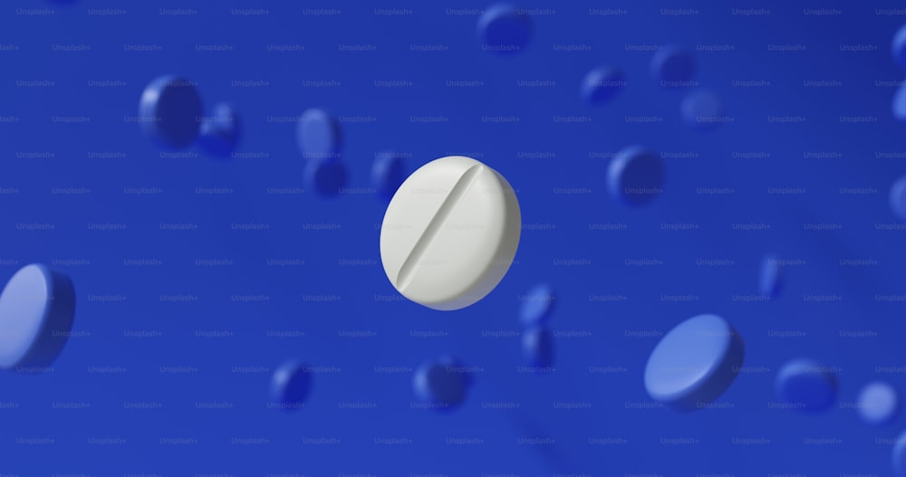 a white pill sitting on top of a blue surface