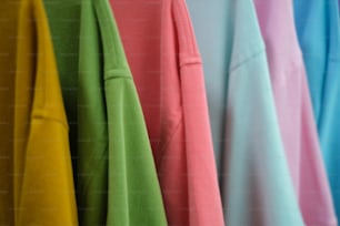 uma fileira de camisas coloridas penduradas em um rack