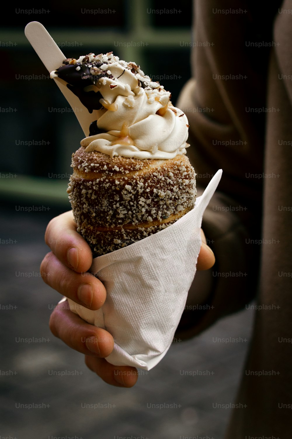 a person holding a pastry in their hand