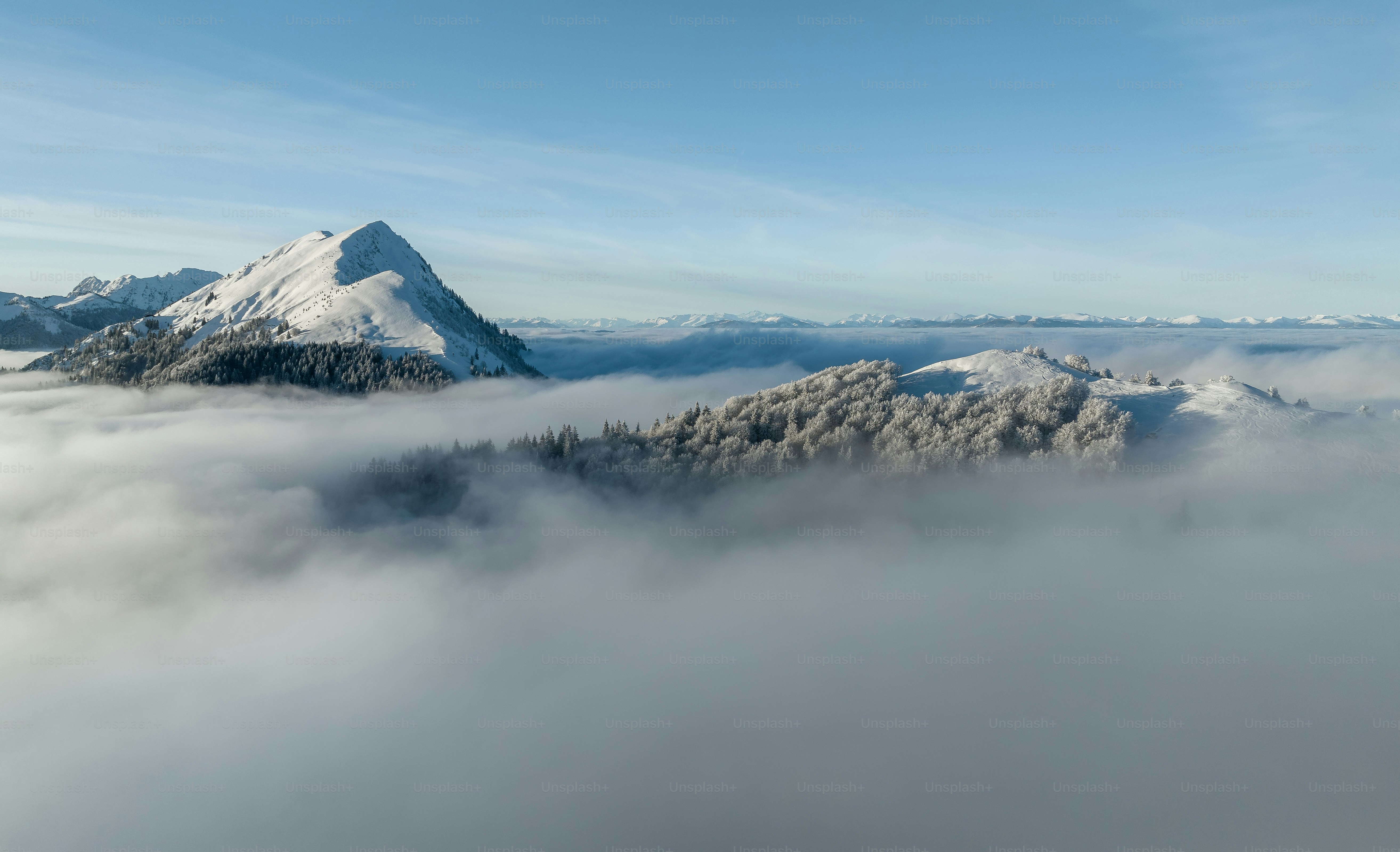 Una montagna coperta di neve e circondata da nuvole