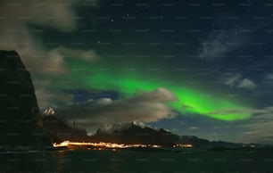 a green and white aurora bore in the night sky