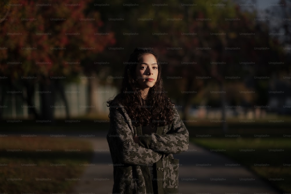 a woman standing on a sidewalk with her arms crossed