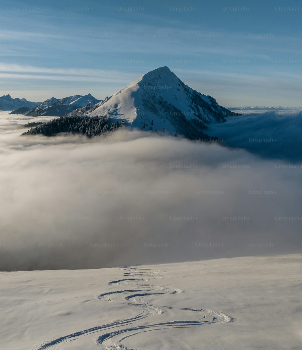 a snow covered mountain with tracks in the snow