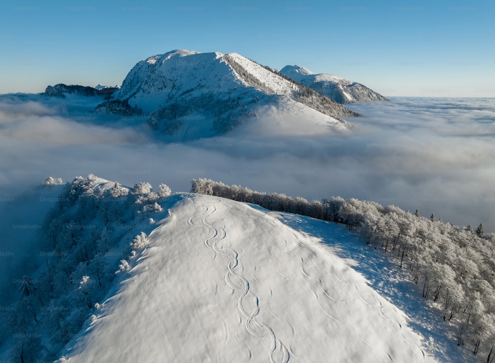 Una montagna coperta di neve e circondata da nuvole