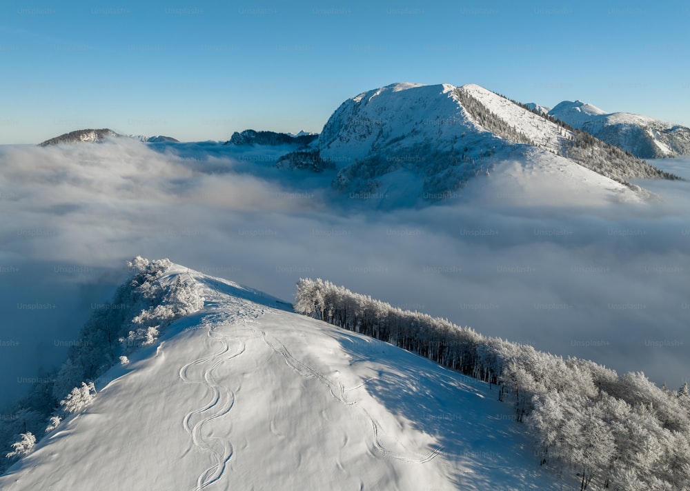 Una montagna coperta di neve e nuvole con uno sfondo del cielo