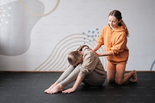 Una donna sta aiutando un'altra donna a sedersi sul pavimento