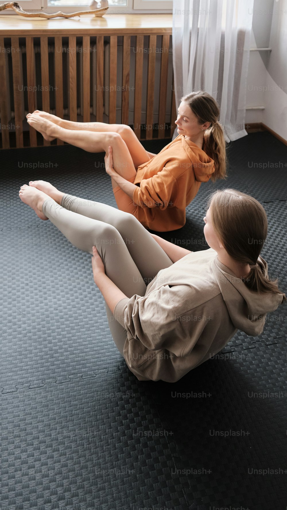 Due donne sedute sul pavimento in una stanza