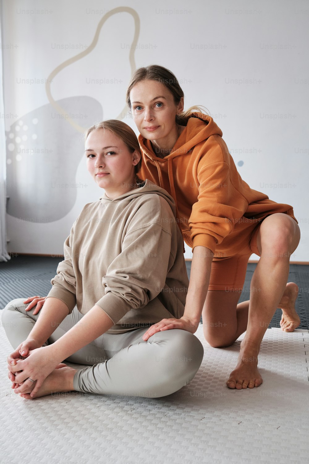 a woman and a girl are sitting on the floor