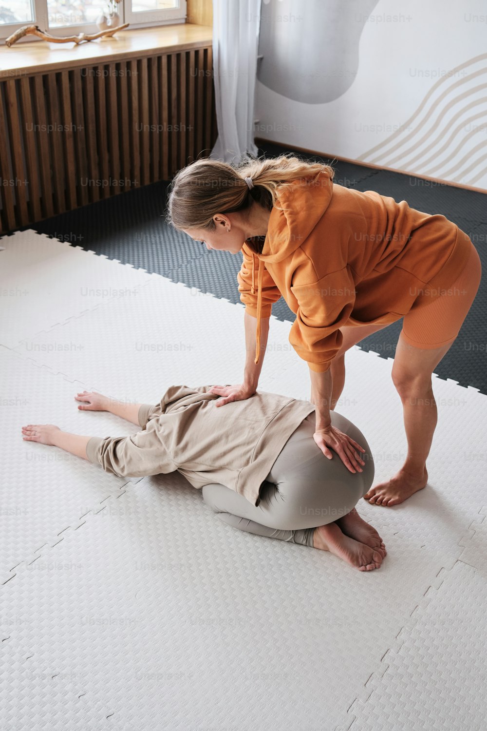 a woman helping a man on a mattress