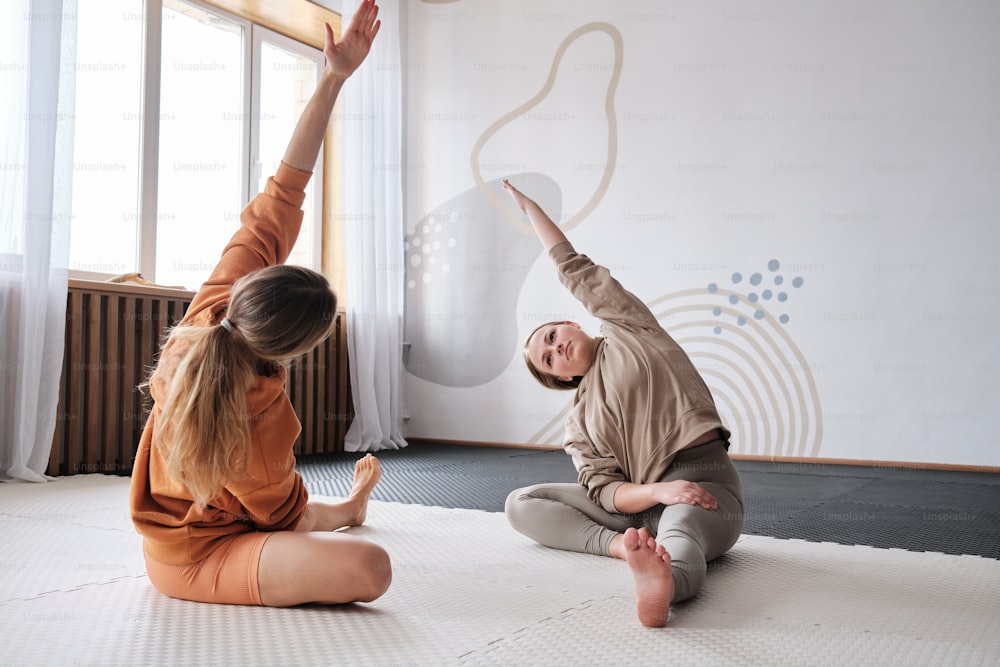um homem e uma mulher fazendo yoga em um tapete