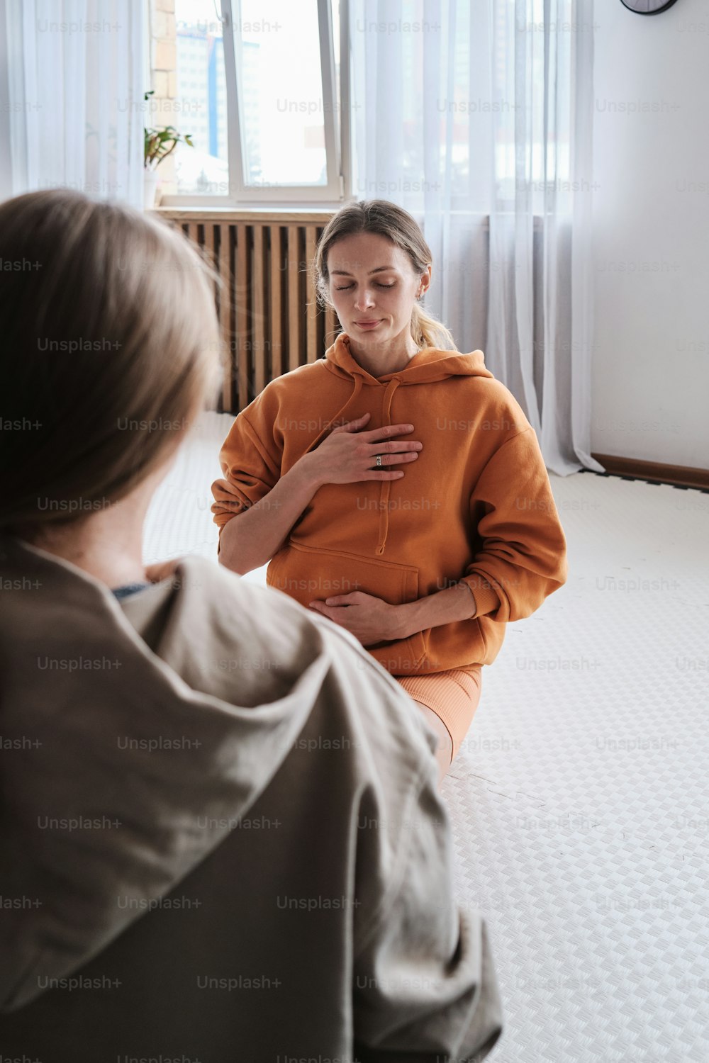 Une femme assise par terre devant un miroir