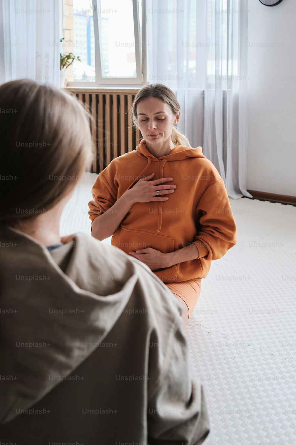 a woman sitting on the floor in front of a mirror