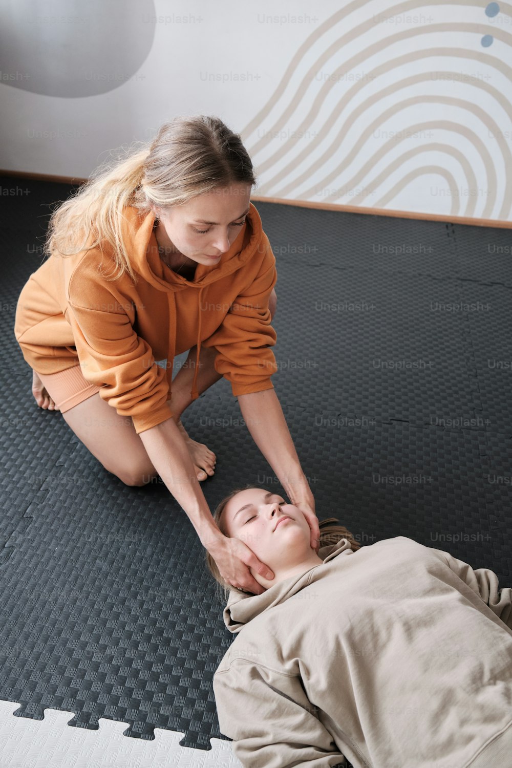 Una donna che aiuta una ragazza sul pavimento