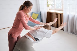 Eine Frau hilft einem Kind mit ihrem Bein