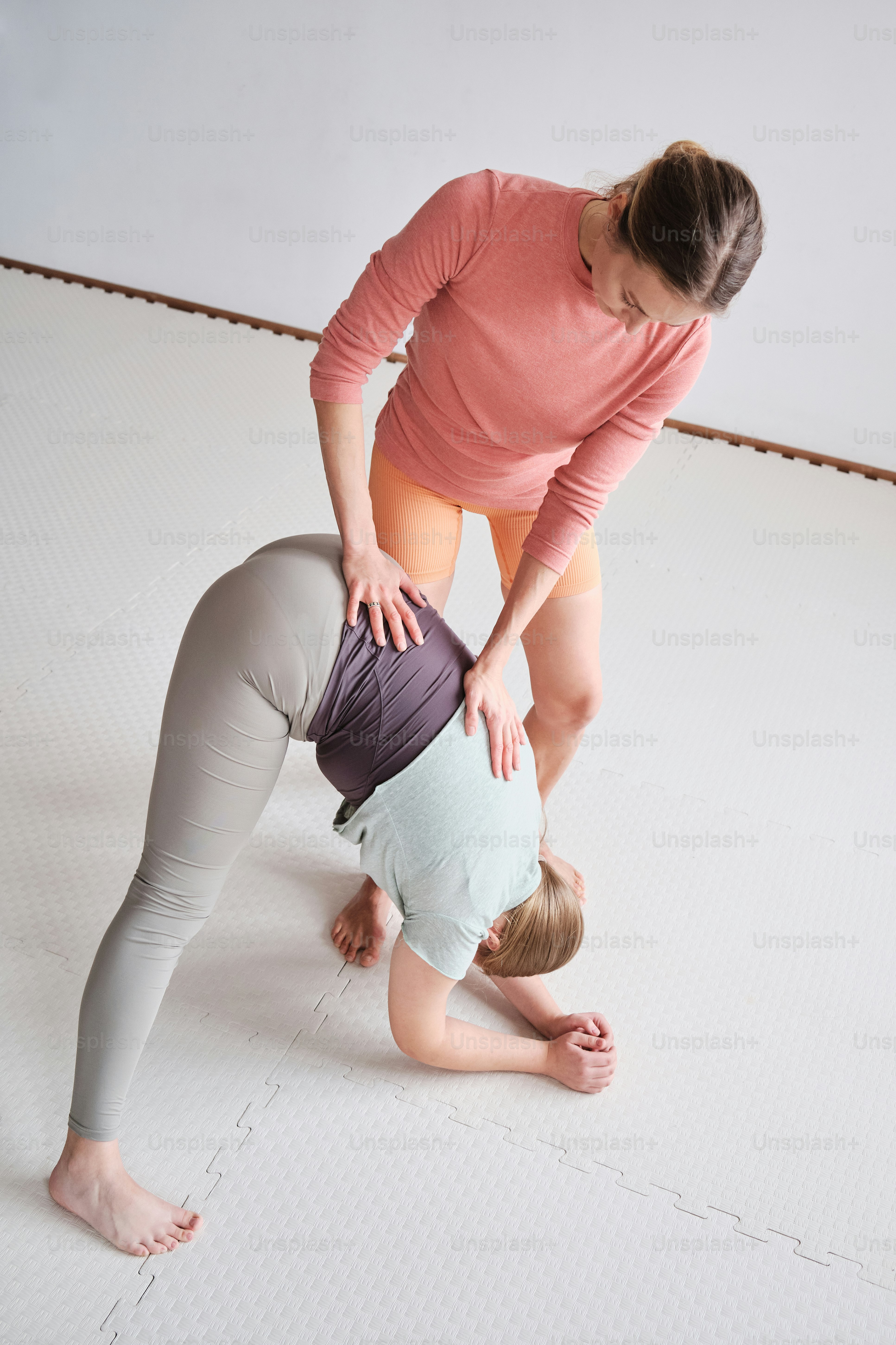 Yoga teacher helps to do yoga asana