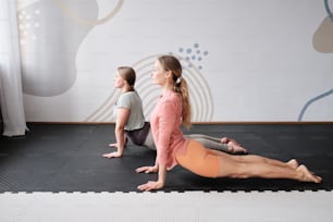 a couple of women sitting on top of a yoga mat