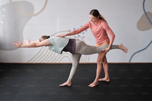 a woman doing a handstand on another woman