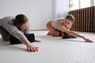 two women are laying on the floor with their hands on the floor