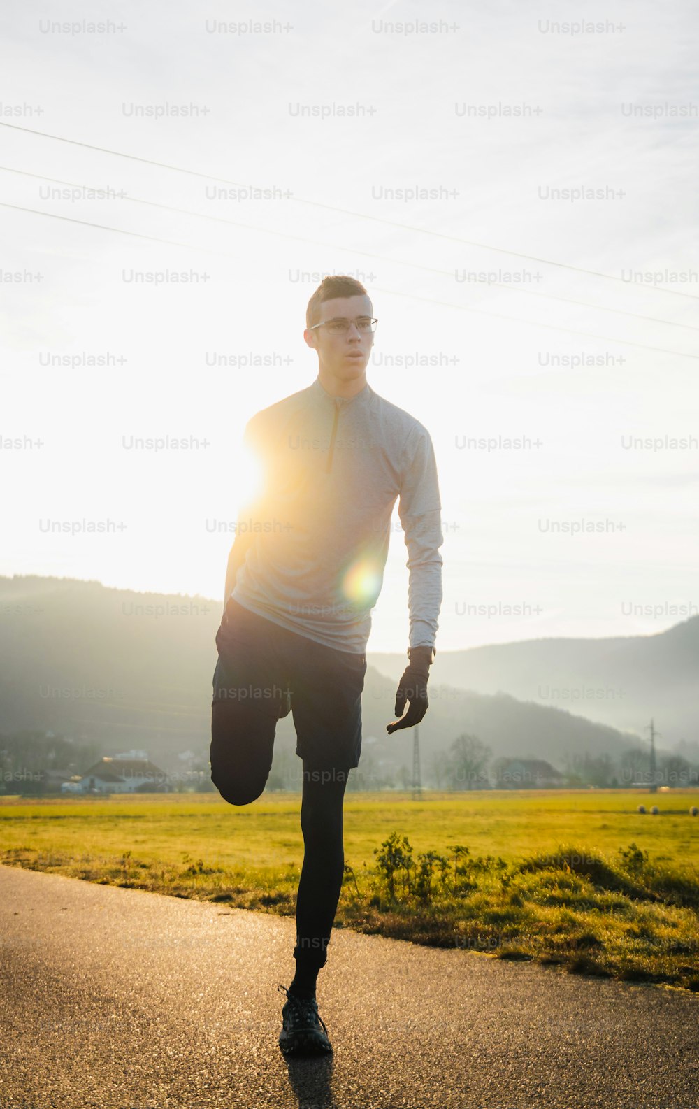 um homem correndo por uma estrada ao sol
