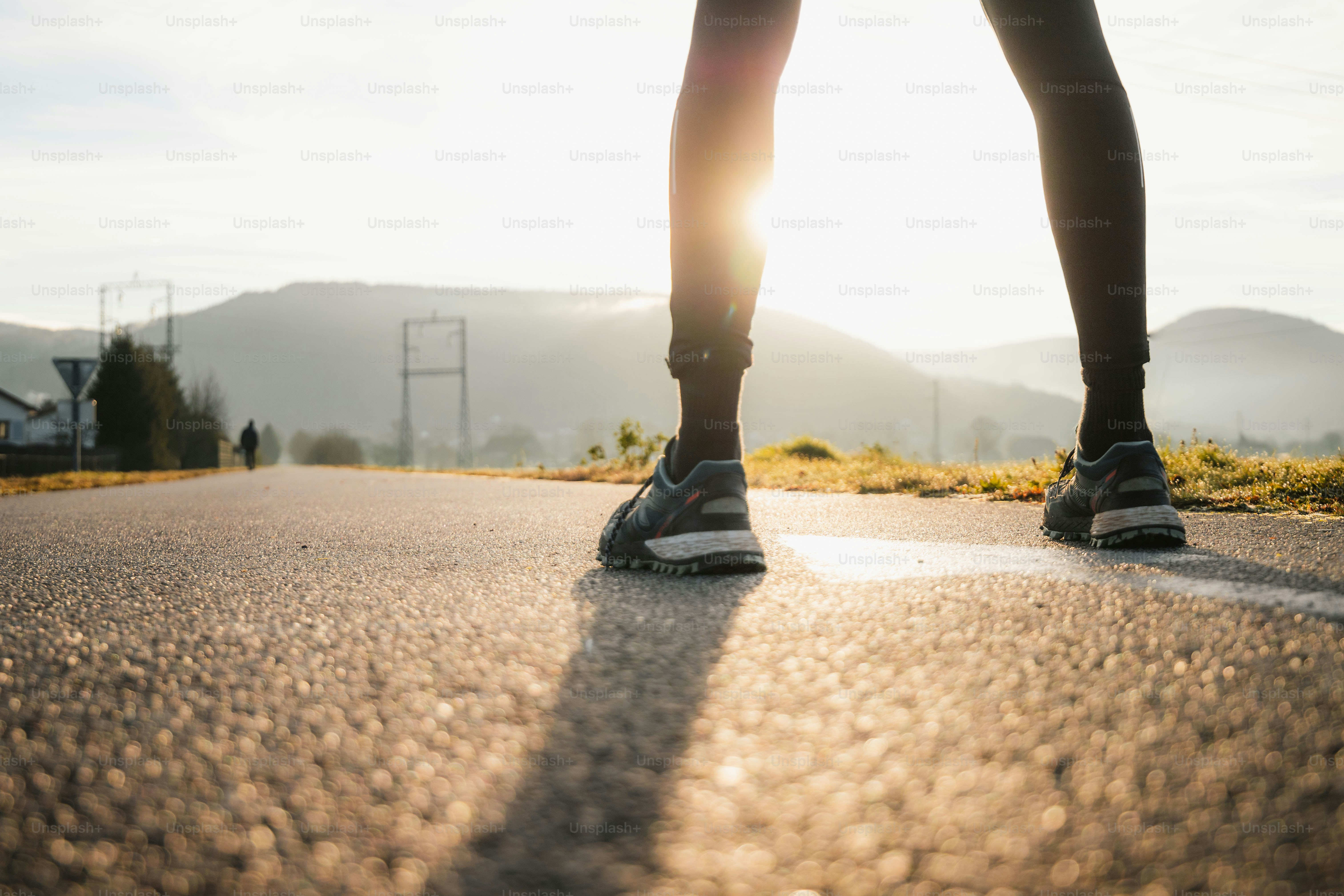 a person standing on a road with their legs crossed