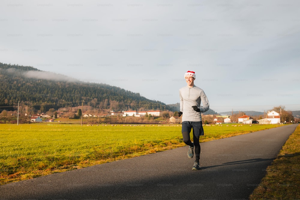 Un hombre con sombrero de Santa corriendo por una carretera